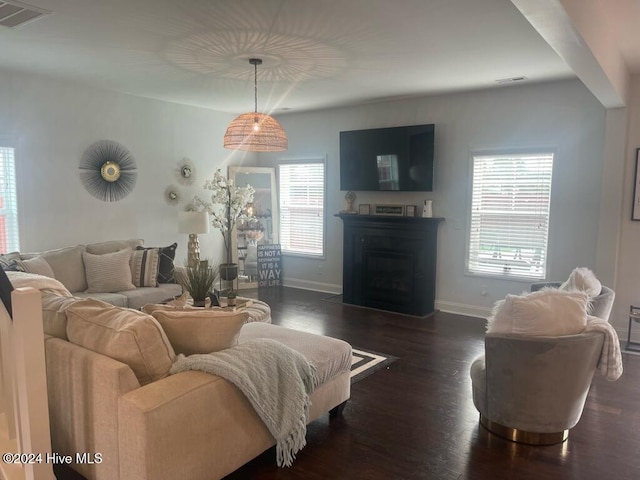 living room with a wealth of natural light and dark wood-type flooring