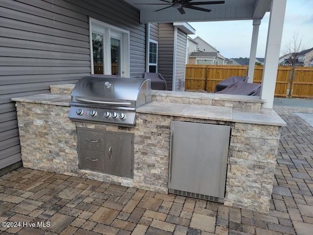 view of patio with grilling area, ceiling fan, and exterior kitchen