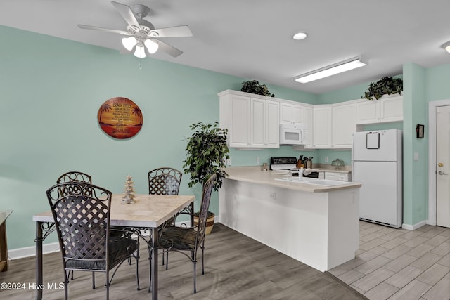 kitchen with ceiling fan, white cabinetry, white appliances, and kitchen peninsula