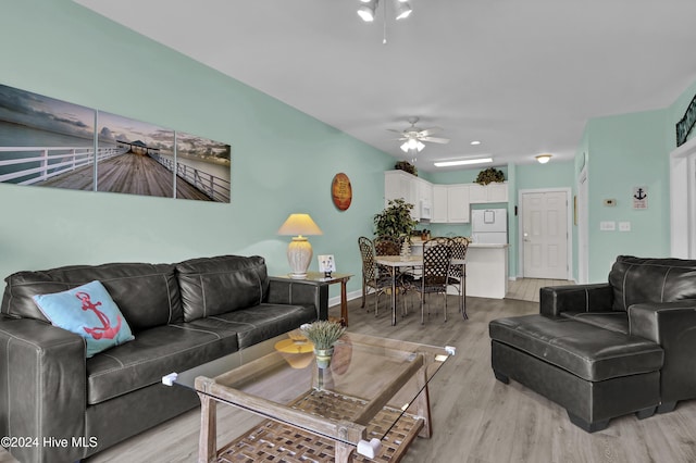 living room with ceiling fan and light hardwood / wood-style flooring