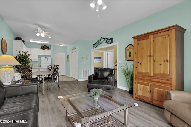 living room with ceiling fan and light hardwood / wood-style flooring