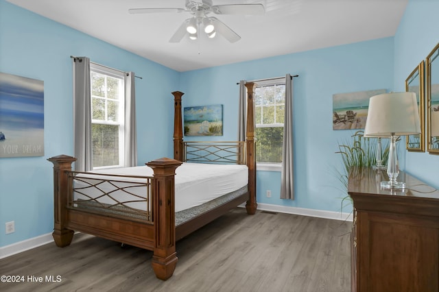 bedroom with multiple windows, ceiling fan, and light hardwood / wood-style floors