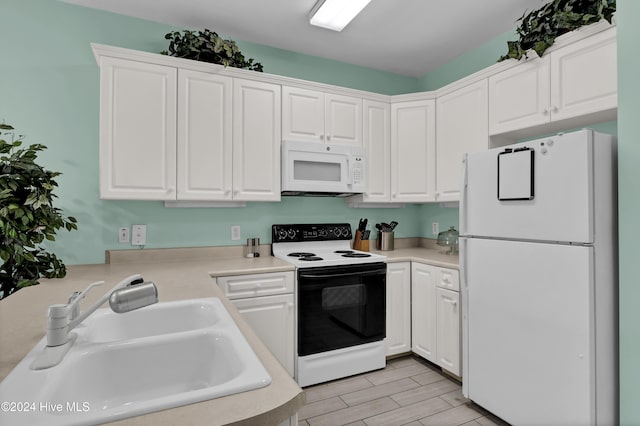 kitchen featuring white cabinets, white appliances, and sink