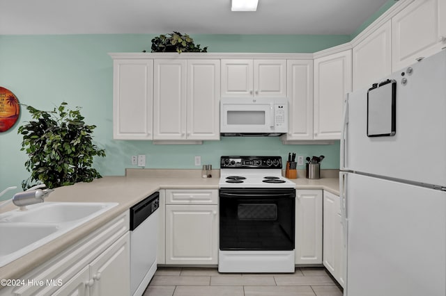 kitchen with white cabinetry, sink, light tile patterned floors, and white appliances