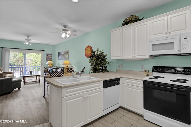 kitchen featuring white appliances, white cabinets, sink, light wood-type flooring, and kitchen peninsula