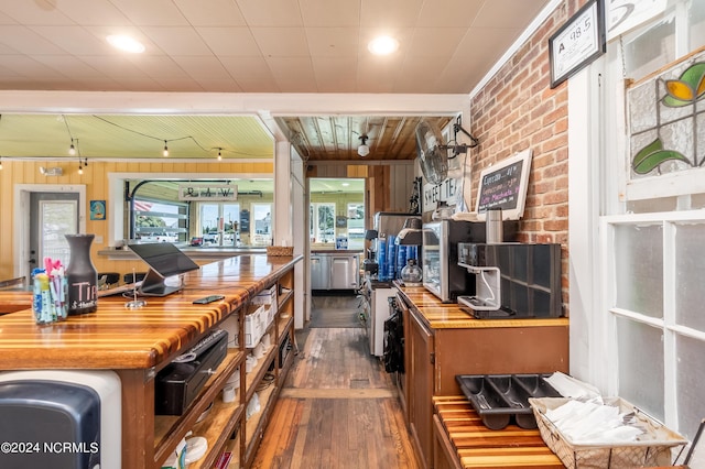 kitchen with butcher block countertops, dark hardwood / wood-style floors, and wood walls