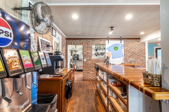 kitchen featuring dark hardwood / wood-style floors, brick wall, and wooden counters