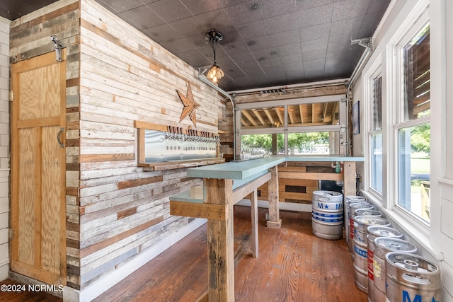 interior space with dark hardwood / wood-style floors and wood walls