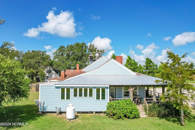 back of house with a yard and covered porch