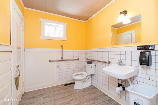 bathroom featuring ornamental molding, sink, hardwood / wood-style flooring, tile walls, and toilet