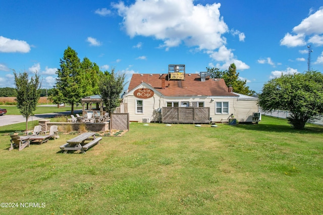 back of house featuring a wooden deck and a yard