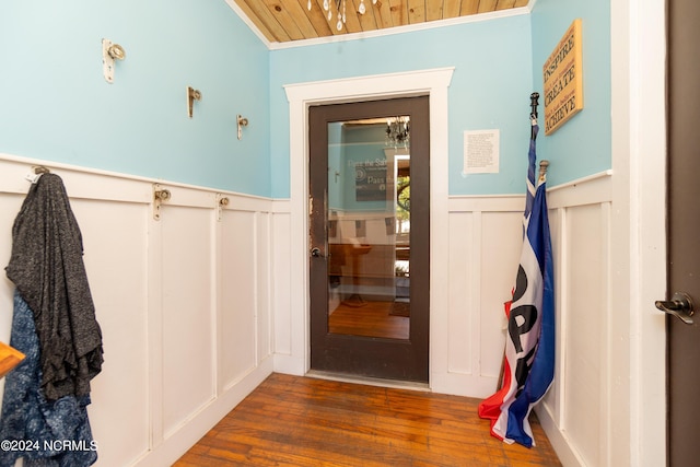 entryway featuring dark hardwood / wood-style flooring, ornamental molding, and wooden ceiling