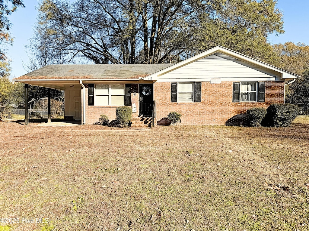 ranch-style house featuring a carport and a front lawn