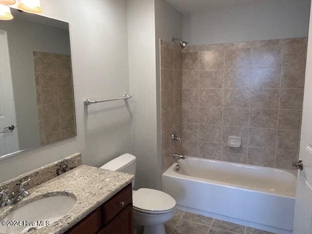 full bathroom featuring tile patterned flooring, vanity, tiled shower / bath combo, and toilet