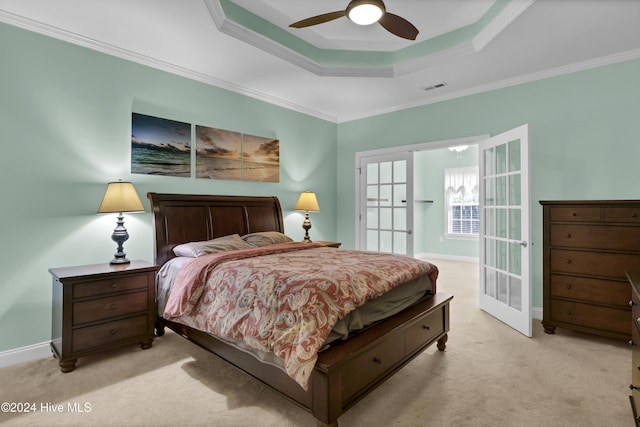 carpeted bedroom featuring a tray ceiling, ceiling fan, french doors, and ornamental molding