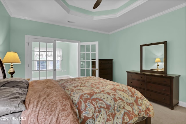 bedroom with a tray ceiling, ceiling fan, light colored carpet, and ornamental molding