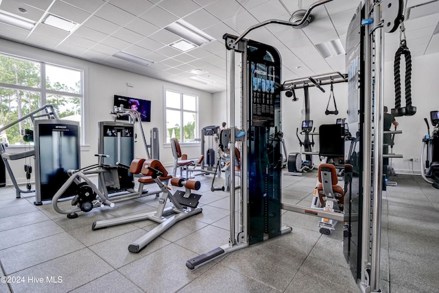 gym featuring a paneled ceiling and plenty of natural light