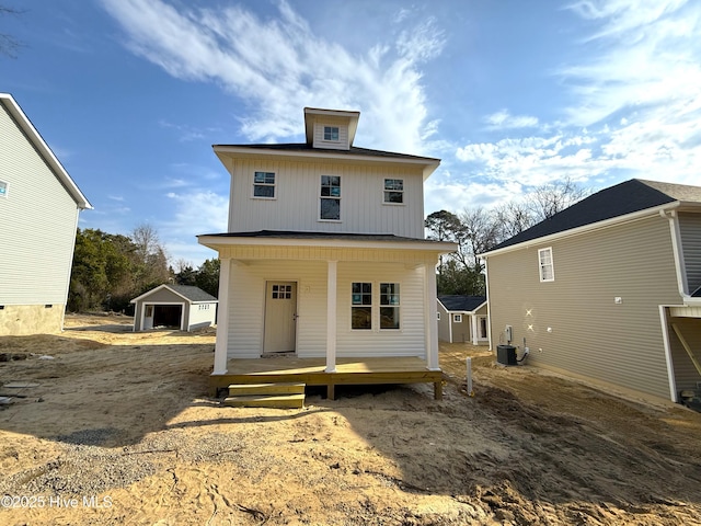 back of property with board and batten siding, a porch, cooling unit, and an outdoor structure