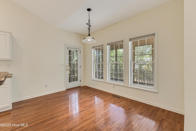 3882 White Blossom Cir, Southport, NC 28461 - unfurnished dining area with light wood finished floors, baseboards, and visible vents