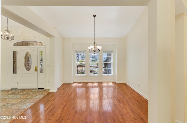 3882 White Blossom Cir, Southport, NC 28461 - entryway featuring light wood-style flooring, a notable chandelier, lofted ceiling, and baseboards