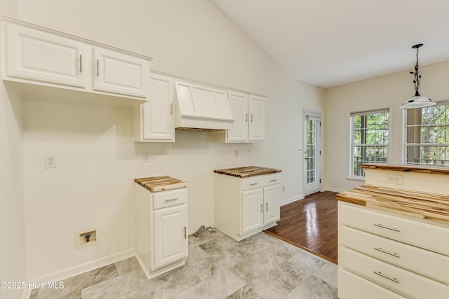 3882 White Blossom Cir, Southport, NC 28461 - kitchen featuring pendant lighting, butcher block counters, white cabinetry, vaulted ceiling, and baseboards