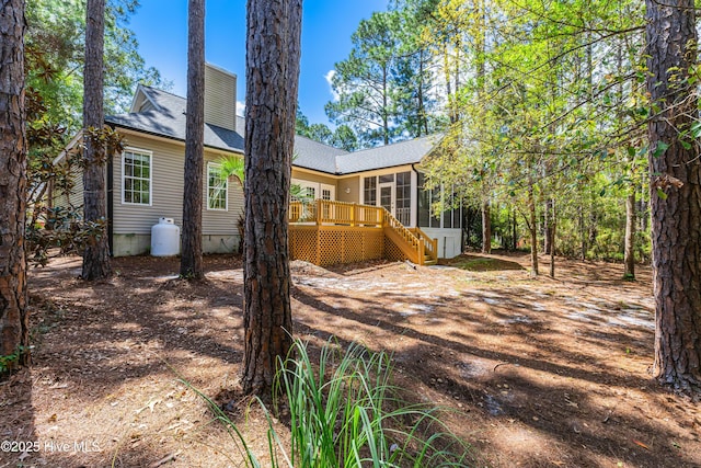 3882 White Blossom Cir, Southport, NC 28461 - rear view of house with a sunroom, roof with shingles, a deck, and stairs