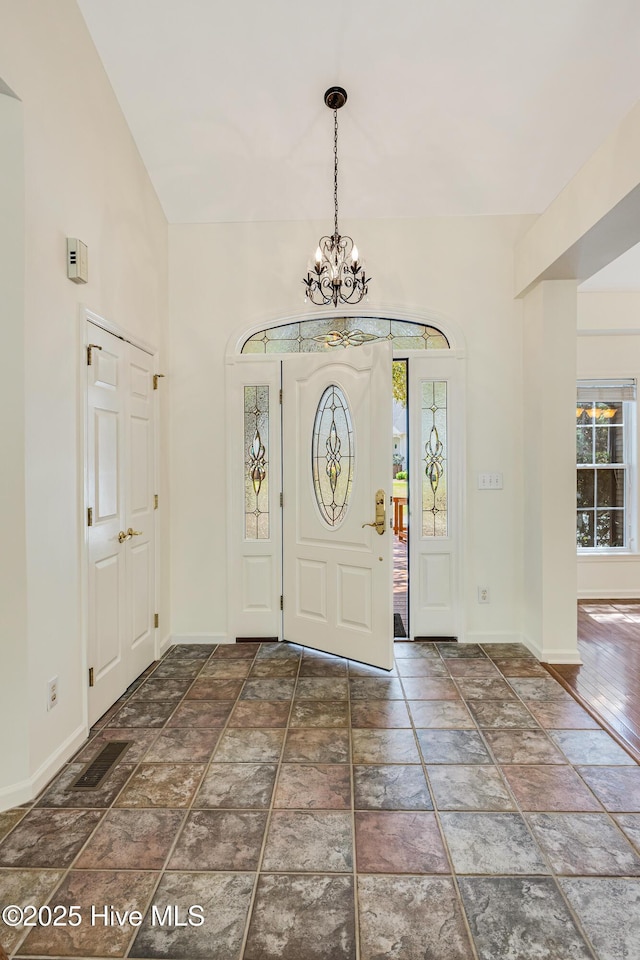 3882 White Blossom Cir, Southport, NC 28461 - foyer entrance featuring a chandelier, stone finish floor, and baseboards