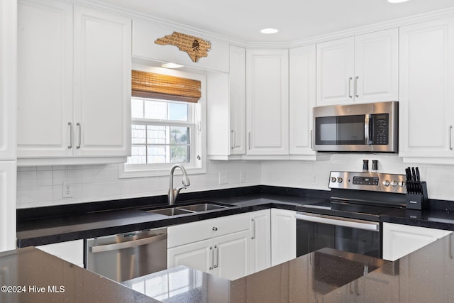 kitchen with appliances with stainless steel finishes, tasteful backsplash, white cabinetry, and sink