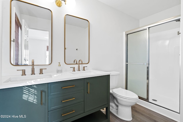 bathroom with toilet, vanity, wood-type flooring, and walk in shower