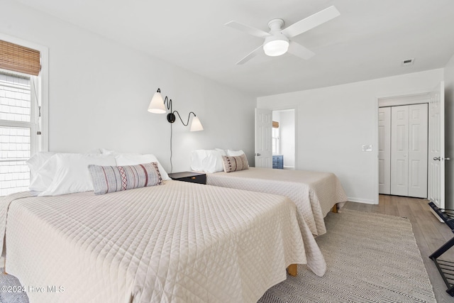 bedroom with ceiling fan, light wood-type flooring, and a closet