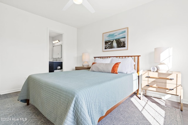 bedroom with ensuite bathroom, light hardwood / wood-style flooring, and ceiling fan