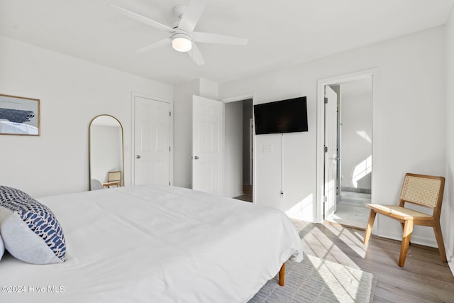 bedroom with ensuite bathroom, ceiling fan, and light hardwood / wood-style floors