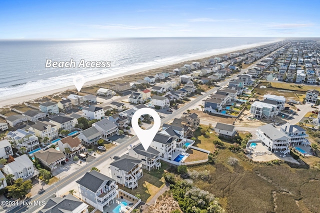 drone / aerial view featuring a water view and a beach view