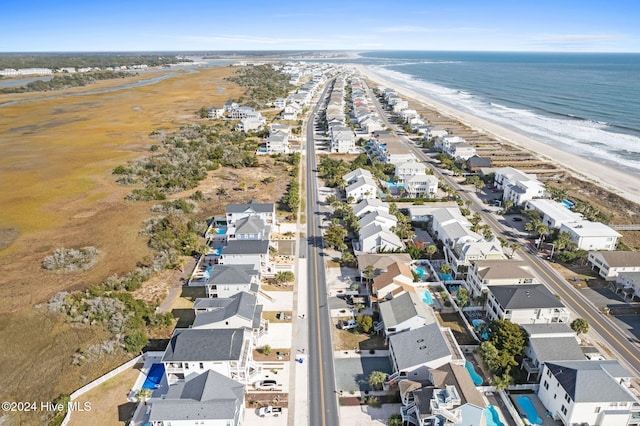 birds eye view of property featuring a water view and a beach view