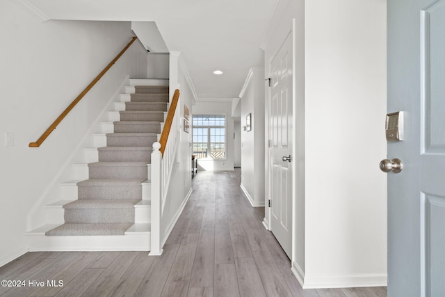 entrance foyer featuring light wood-type flooring and ornamental molding