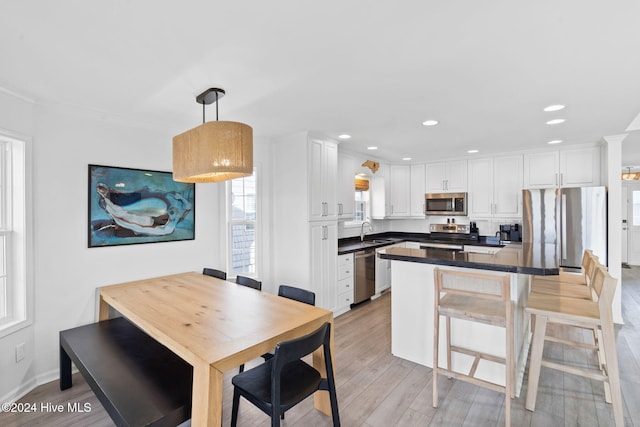 kitchen with white cabinets, pendant lighting, kitchen peninsula, and appliances with stainless steel finishes