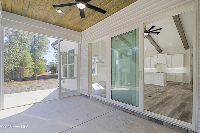 unfurnished sunroom with vaulted ceiling with beams and ceiling fan with notable chandelier