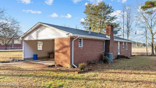 view of side of property featuring a lawn and cooling unit