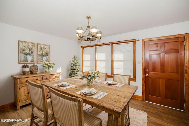 dining room with dark hardwood / wood-style flooring and a chandelier