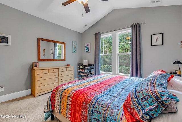 carpeted bedroom with lofted ceiling, baseboards, visible vents, and a ceiling fan