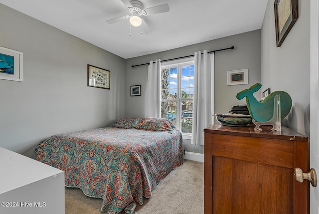 bedroom with light colored carpet, ceiling fan, and baseboards