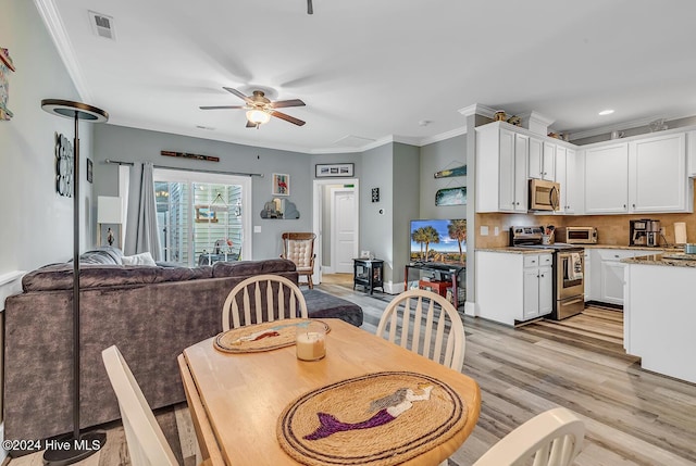 dining space with visible vents, ornamental molding, a ceiling fan, light wood-type flooring, and baseboards