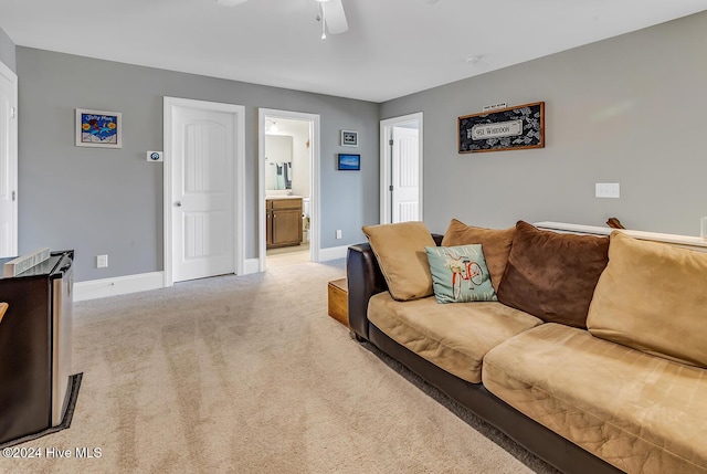 living room with light colored carpet, ceiling fan, and baseboards