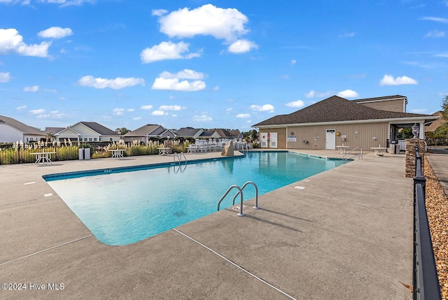 pool featuring a residential view, fence, and a patio