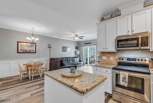 kitchen featuring open floor plan, appliances with stainless steel finishes, a kitchen island, and white cabinetry