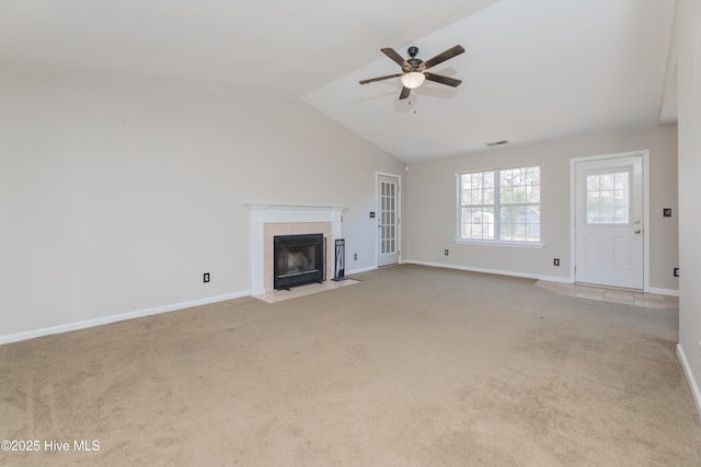 unfurnished living room featuring ceiling fan, lofted ceiling, light carpet, and a tile fireplace