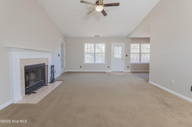 unfurnished living room featuring light carpet, ceiling fan, lofted ceiling, and a tiled fireplace