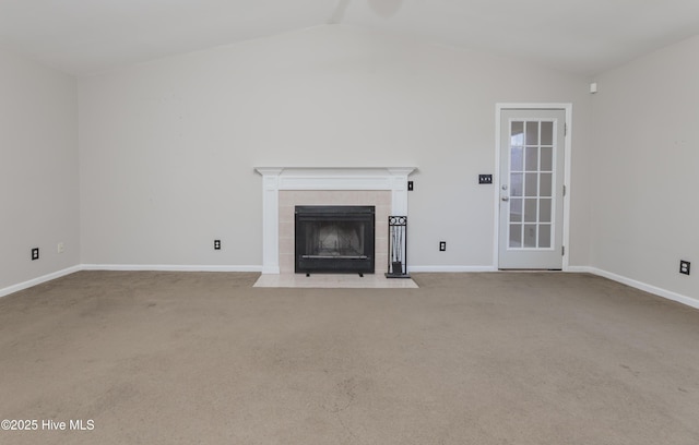 unfurnished living room featuring a tile fireplace, light colored carpet, and vaulted ceiling