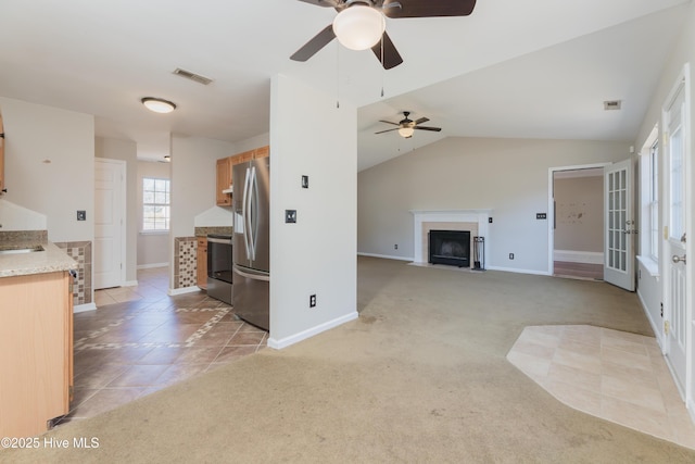 unfurnished living room featuring light carpet, ceiling fan, lofted ceiling, and sink