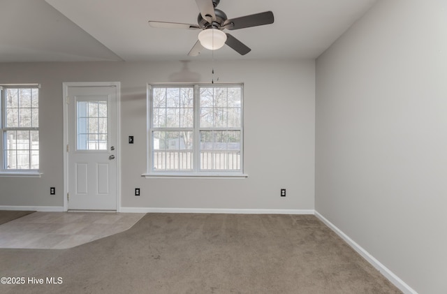 entryway with ceiling fan and light carpet